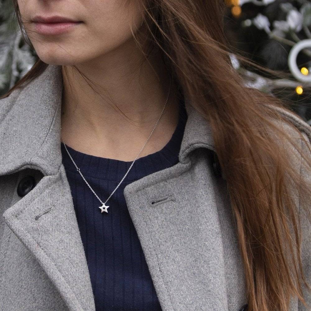 A woman wearing a grey coat and a Hot Diamond Amulet Star Set – SS132.