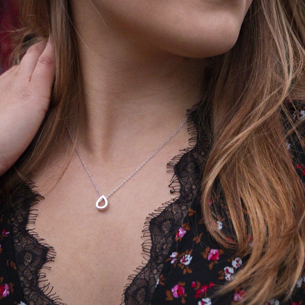 A woman is wearing a necklace with the Diamond Amulet Teardrop Pendant.