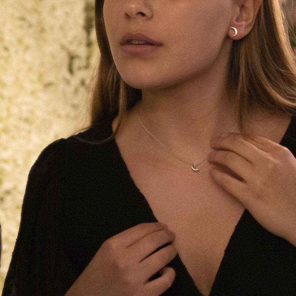 A young woman wearing the HOT DIAMONDS Amulets Crescent Gift Set. – SS133 necklace and earrings.